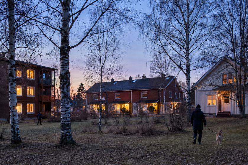 Kerrostalo, rivitalo ja omakotitalo vierekkäin illan sinisessä hetkessä